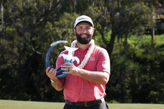 Jon Rahm lifts a trophy following his win at the 2023 Sentry Tournament of Champions