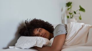 Woman sleeping peacefully on her side and hugging her pillow