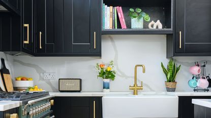 Black painted kitchen cabinets with gold hardware, decorated kitchen worktops