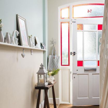 hallway area with white door wooden table and white walls