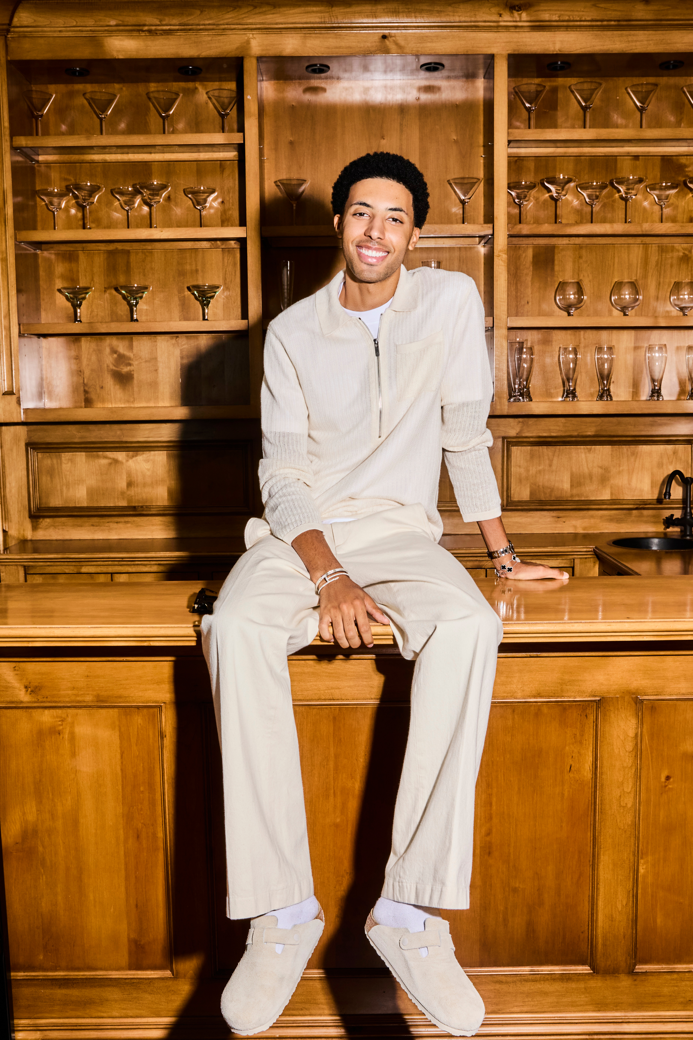 preston pippen in white outfit sitting on a bar in a promotional shot for calabasas confidential