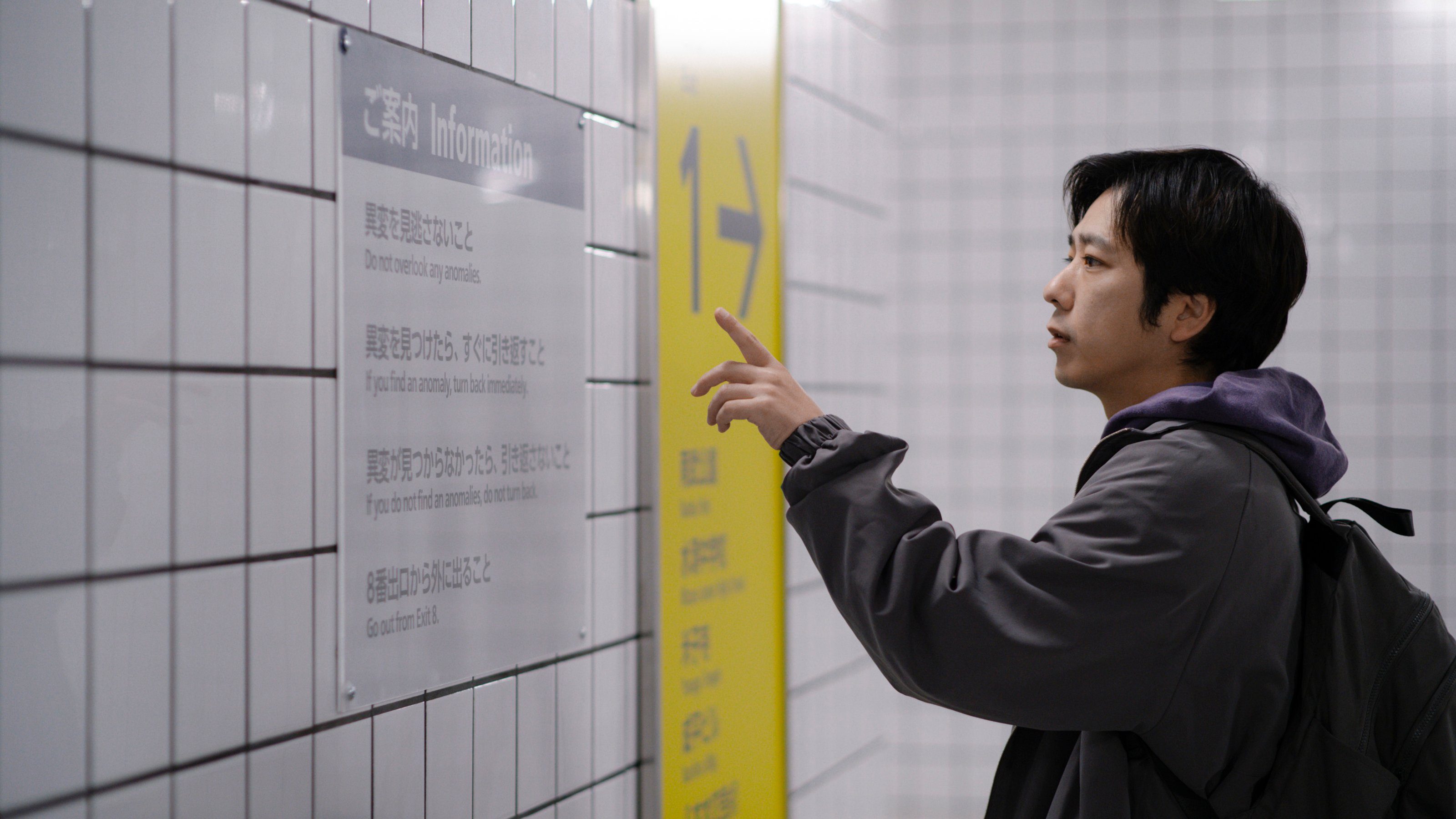 The Lost Man looks at a sign on the Metro wall.