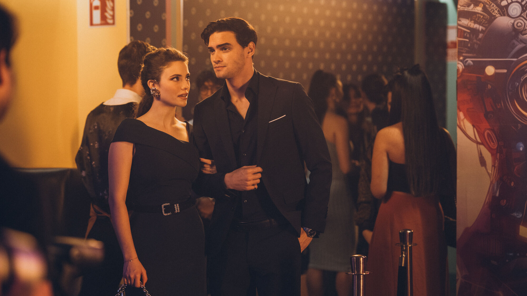 Sofia holds onto Nick's arm at an event.