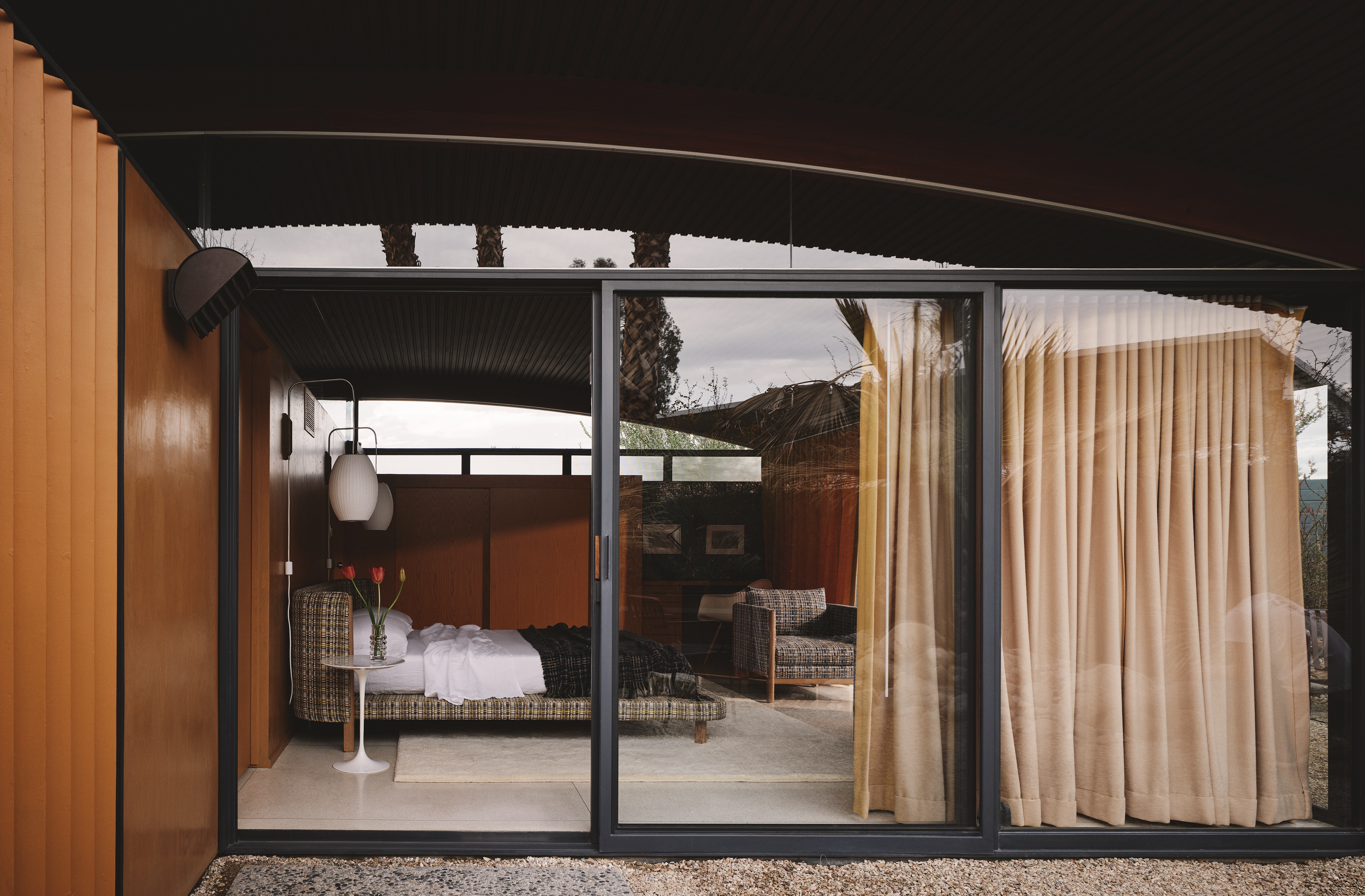 A Californian desert house from the mid 20th-century is furnished with earthy, stripy furnishings and iconic design pieces.