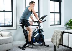 The Horizon Fitness 5.0 IC Smart Bike being ridden by man in bedroom