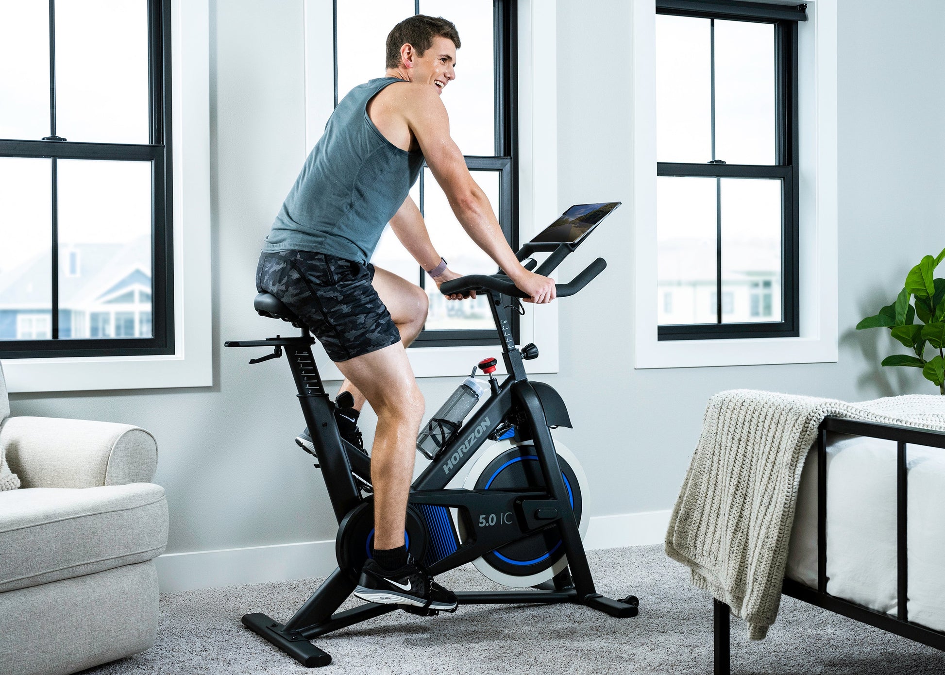 The Horizon Fitness 5.0 IC Smart Bike being ridden by man in bedroom