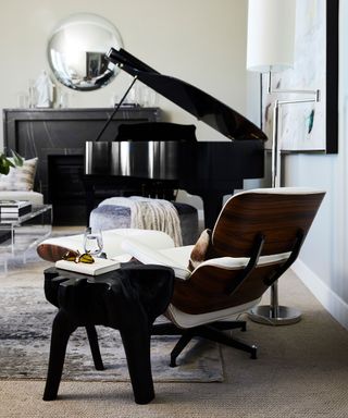 Modern living room with eames lounge chair, piano, round mirror