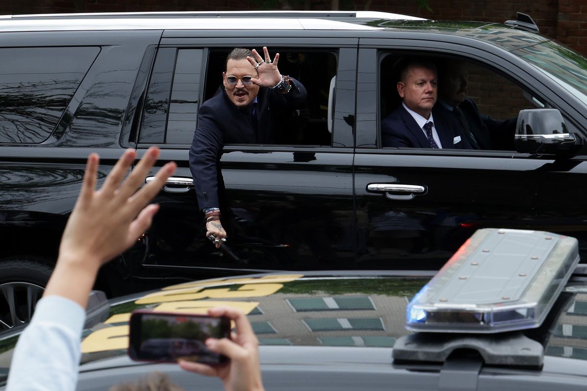 Johnny Depp waves from a car.