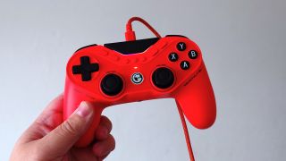 A photo of an orange GameSir Tarantula 8K controller being held in front of a white wall. 
