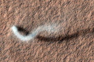 A "serpent" dust devil snakes across Mars. Windblown dust storms like these might be charged with "innumerable small shocks" of electricity, the new study found.