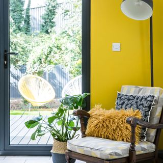 room with yellow wall chair and black frame door