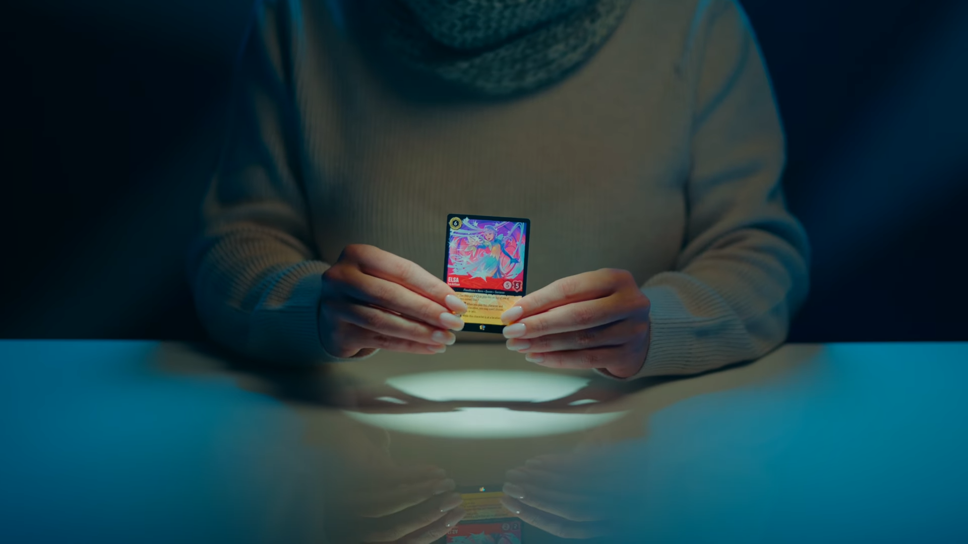 Someone holding an Elsa Disney Lorcana card in their hands, with a spotlight on it