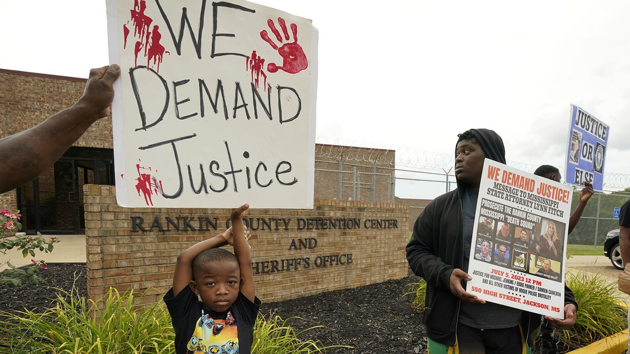 An anti-police brutality activist looks back at the entrance to the Rankin County Sheriff&#039;s Office in Brandon, Miss.