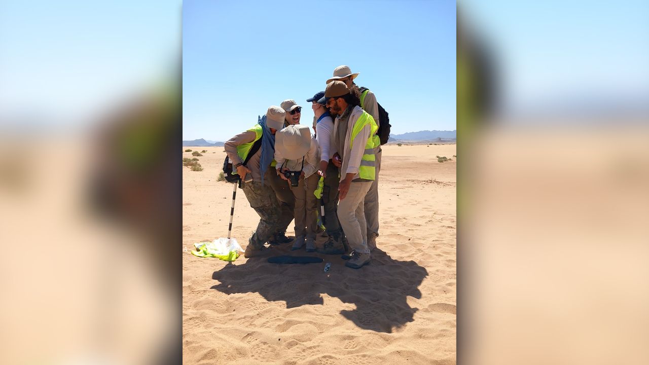 Group of researchers in archaeological site in Saudi Arabia.
