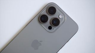 En iPhone 15 Pro ligger med baksidan vänd uppåt mot kameran.