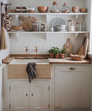 utility room with wooden shelving above sink area