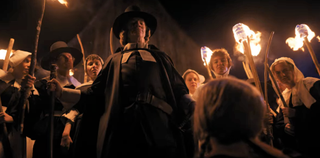 Joseph Crackstone surrounded by other pilgrims with torches