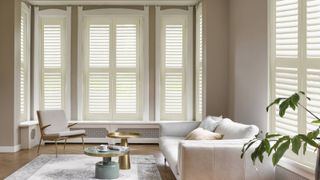living room with double aspect windows fitted with white shutters