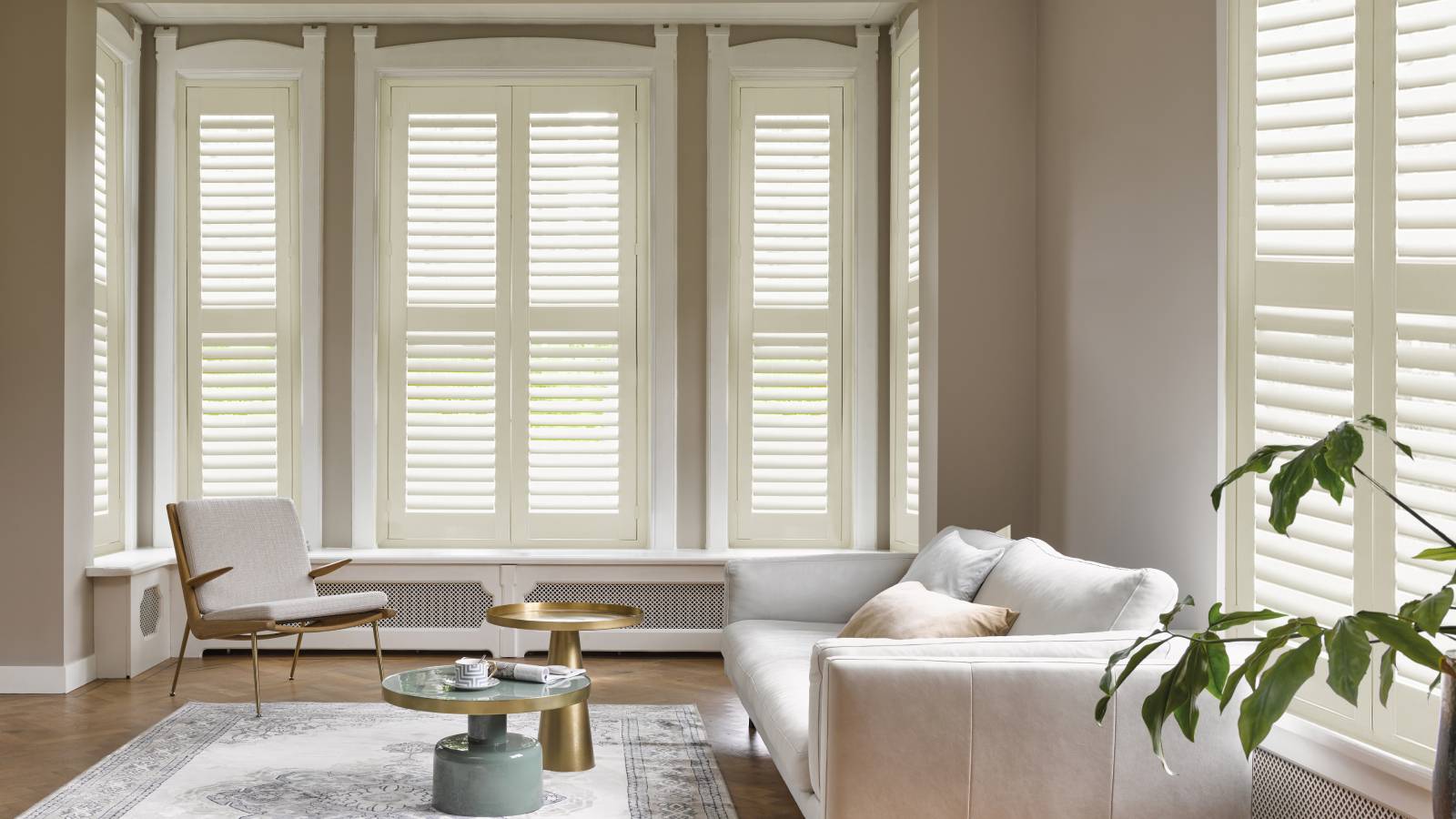 living room with double aspect windows fitted with white shutters