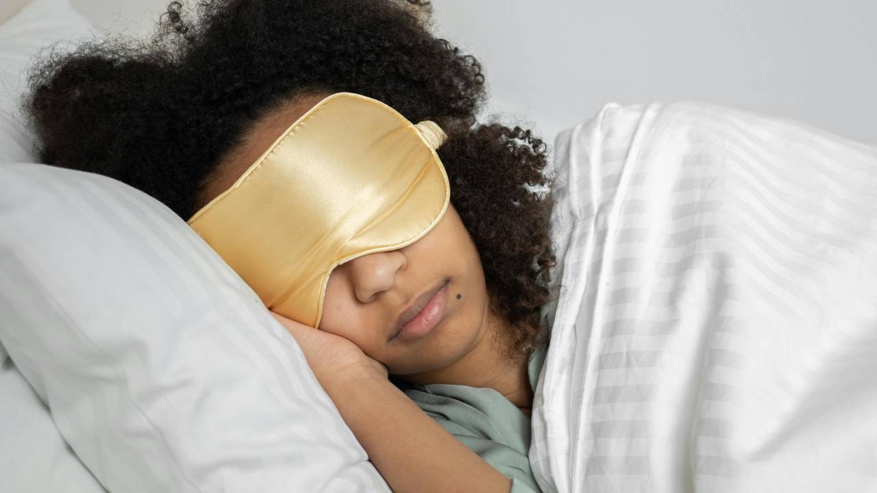A woman sleeping with a yellow eye mask on