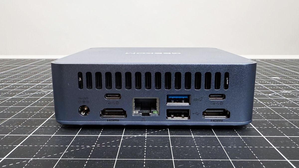 Close up of the rear ports on the Geekom AX8 Pro AI Mini PC on a black mat against a white background.