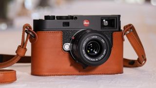 The Leica M11 in a leather case resting on a table