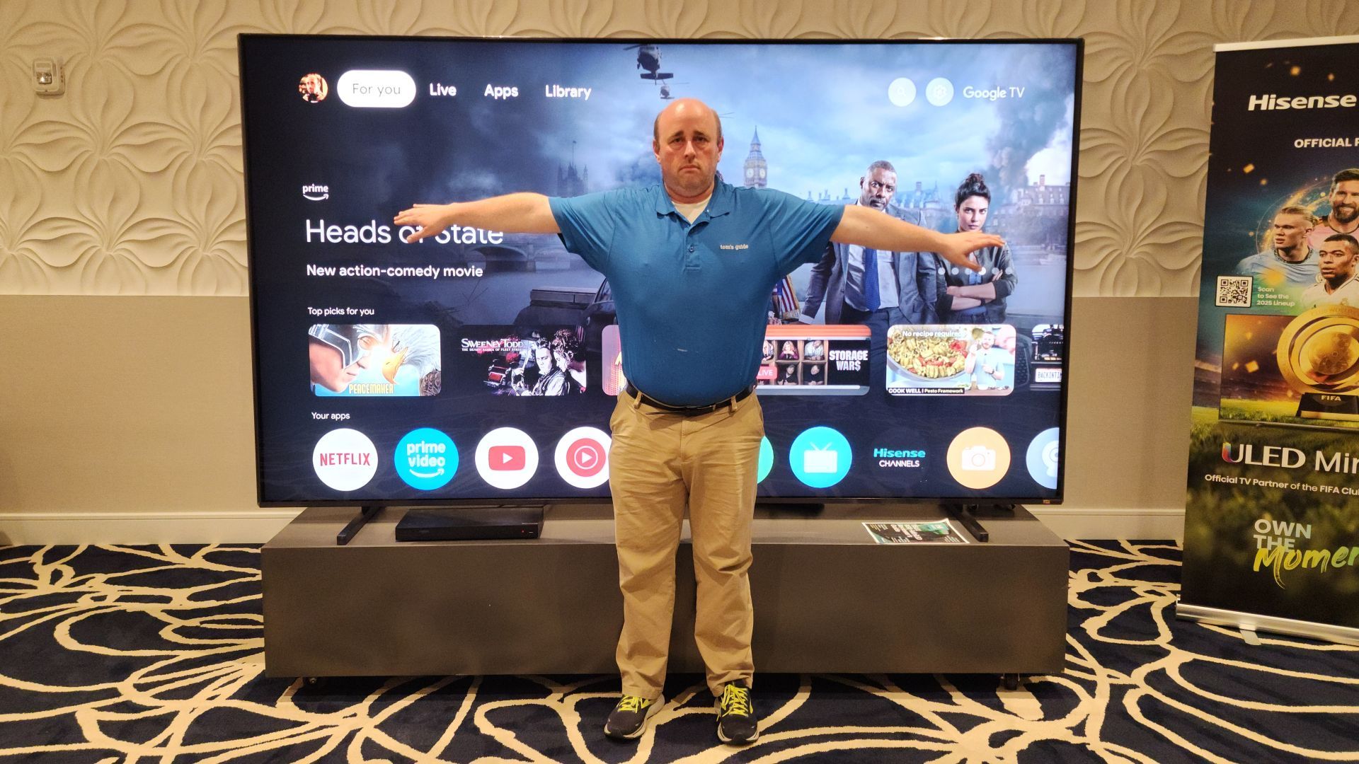 Author Matthew Murray standing in front of Hisense 116UX with arms outstretched