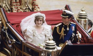 Princess Diana wearing her wedding dress and riding in a carriage with Prince Charles on their wedding day