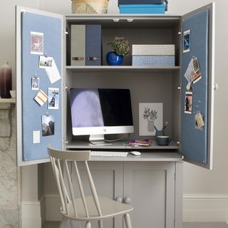 cabinet desk with computer and photos and chair