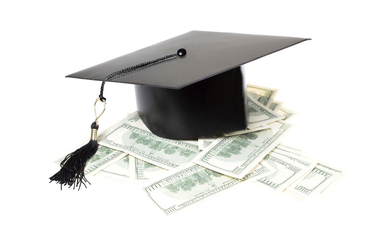 Paid education. Graduate cap on a pile of money