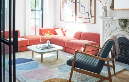 a neutral living room with a coral sofa
