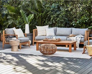 A teak wood outdoor sofa and armchairs