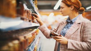woman checking supermarket food label no sugar diet