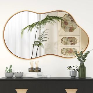 A wavy gold mirror in a neutral-colored living room