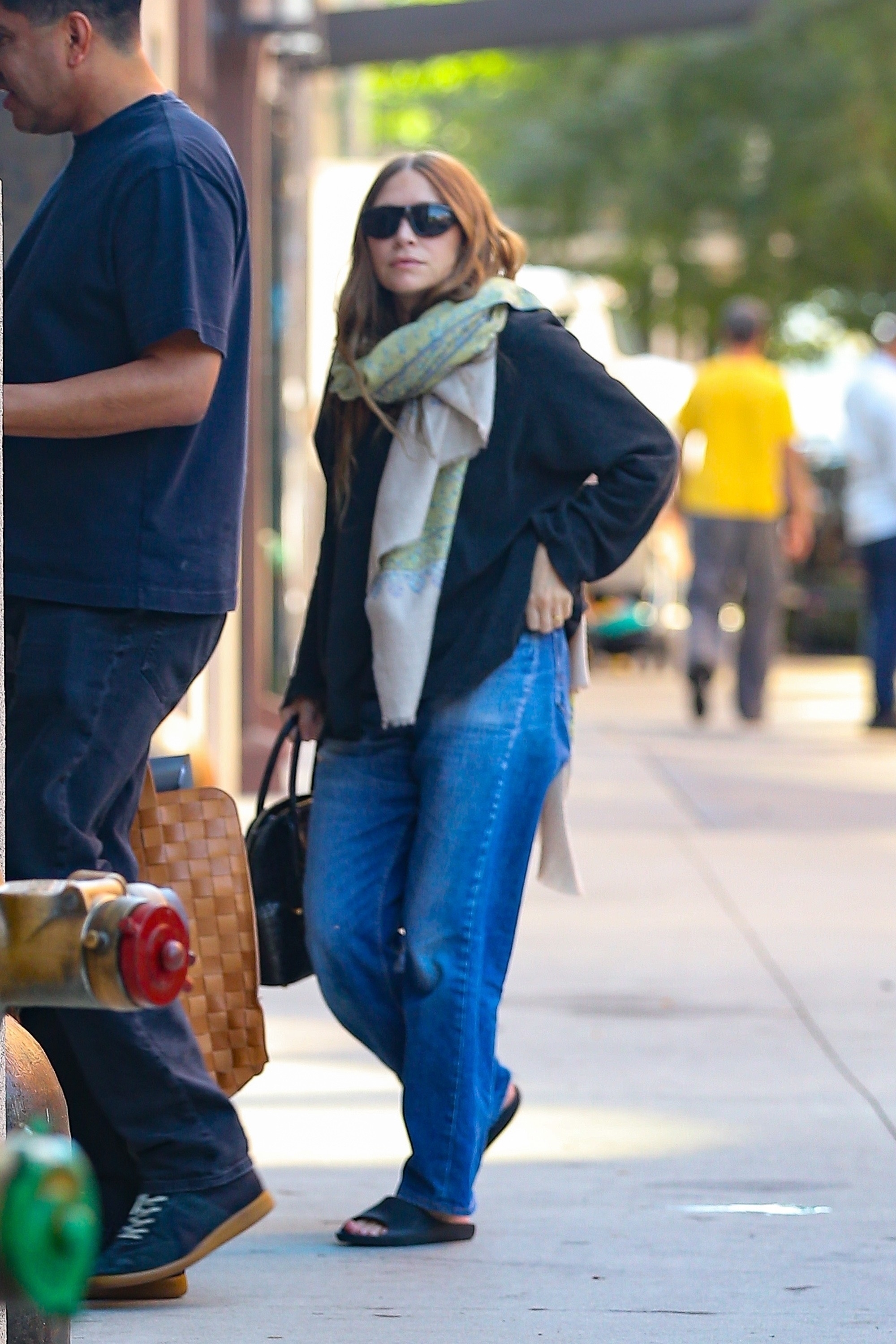 Ashley Olsen wearing jeans, slides, and carrying a rare alligator The Row bag