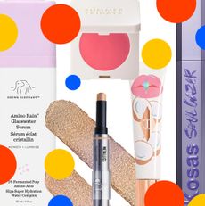 Product collage of Danessa Myricks BeautyColorfix Stix, Drunk Elephant Amino Rain™ Glasswater Serum, Kosas Soulgazer Lengthening Mascara, Summer Fridays Blush Butter Balm, Charlotte Tilbury Unreal Lips Healthy Glow Nectar Oil, on white background with red, yellow, and blue polka dots 