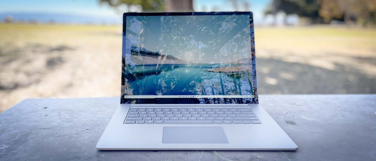 Surface Laptop 5 outdoors on a patio table, screen open showing Windows 11 desktop