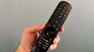 LG A2 OLED TV remote control being held in hand