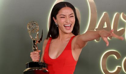 Anna Sawai in red with her Emmy award 