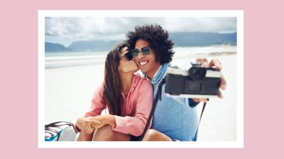 a couple selfie on a sunny day near the mountains while the woman is kissing the guy on the cheek