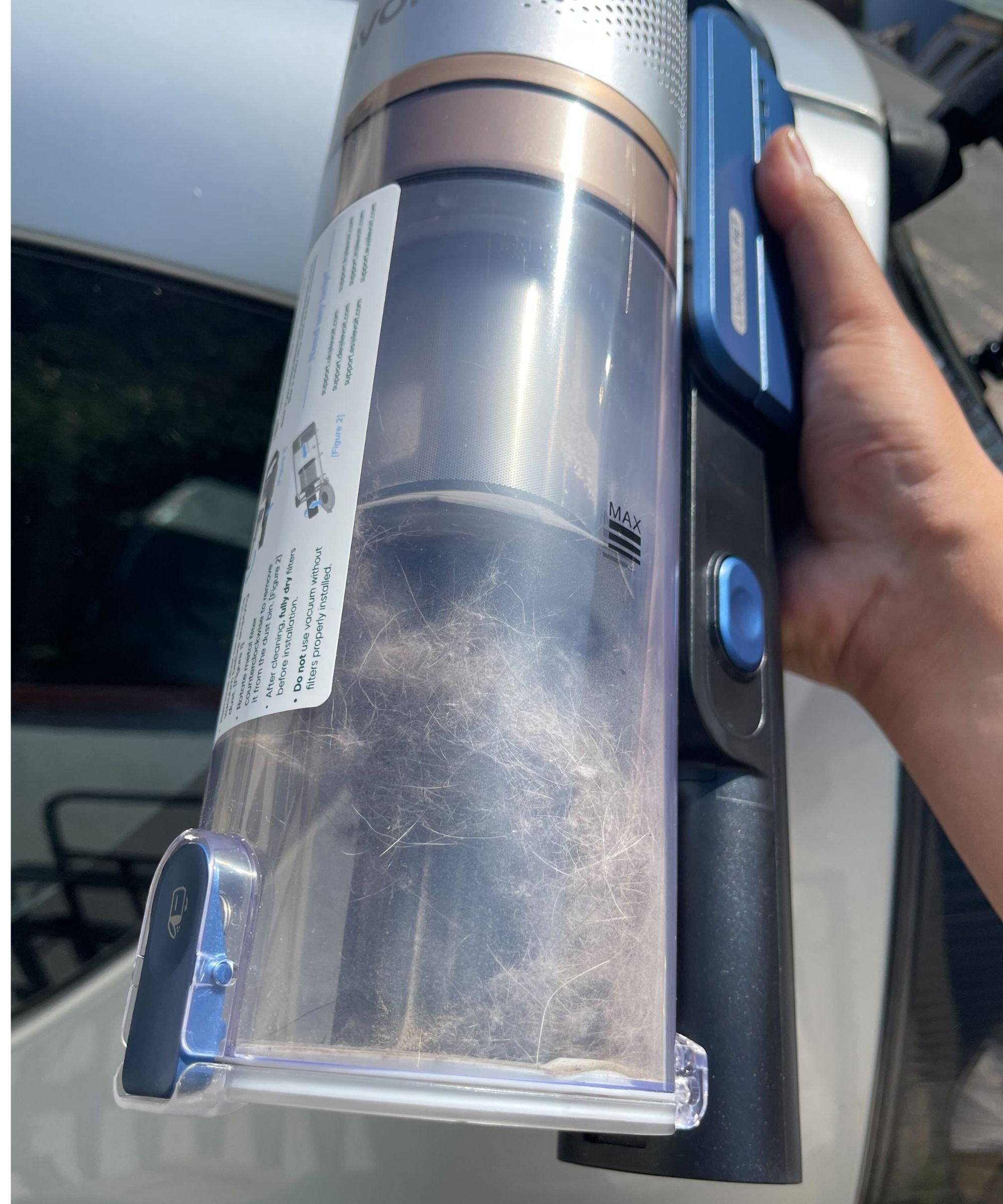 Levoit LVAC-300 dustbin partially full of pet hair in front of silver car, outside Dan Fauzi's home