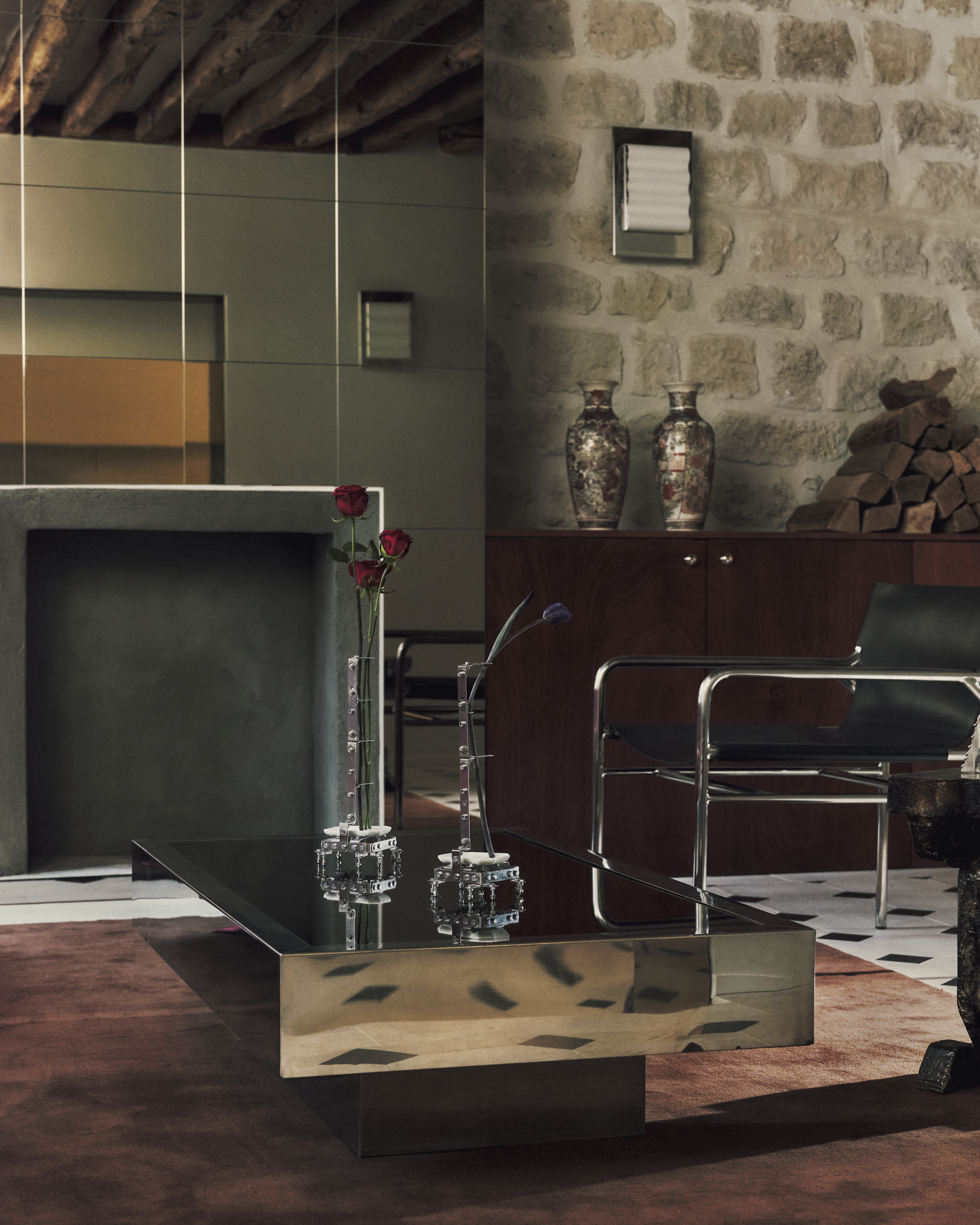 A sleekly designed apartment with tiled white and black checkered floors, chrome surfaces, brick walls, and occasional pops of red, ming green, and butter across linearly cut furniture.