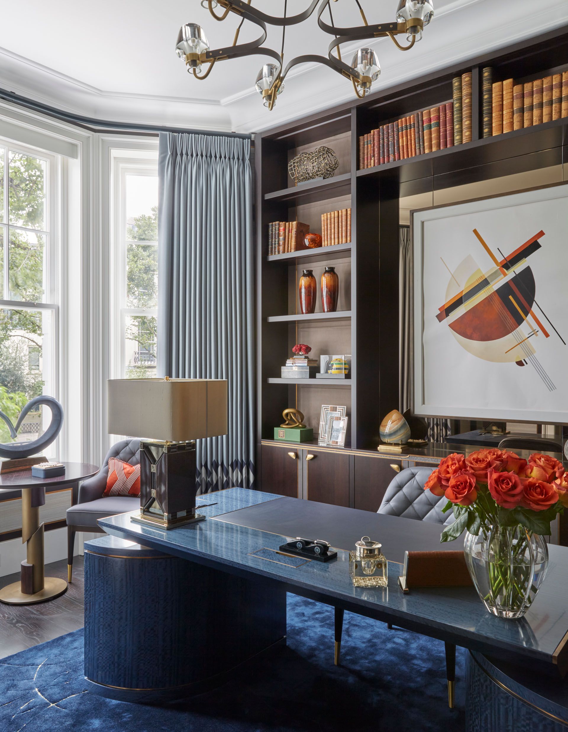 Blue polished stone desk, dark blue carpet with gold lines, gold handles on cabinets and chair legs