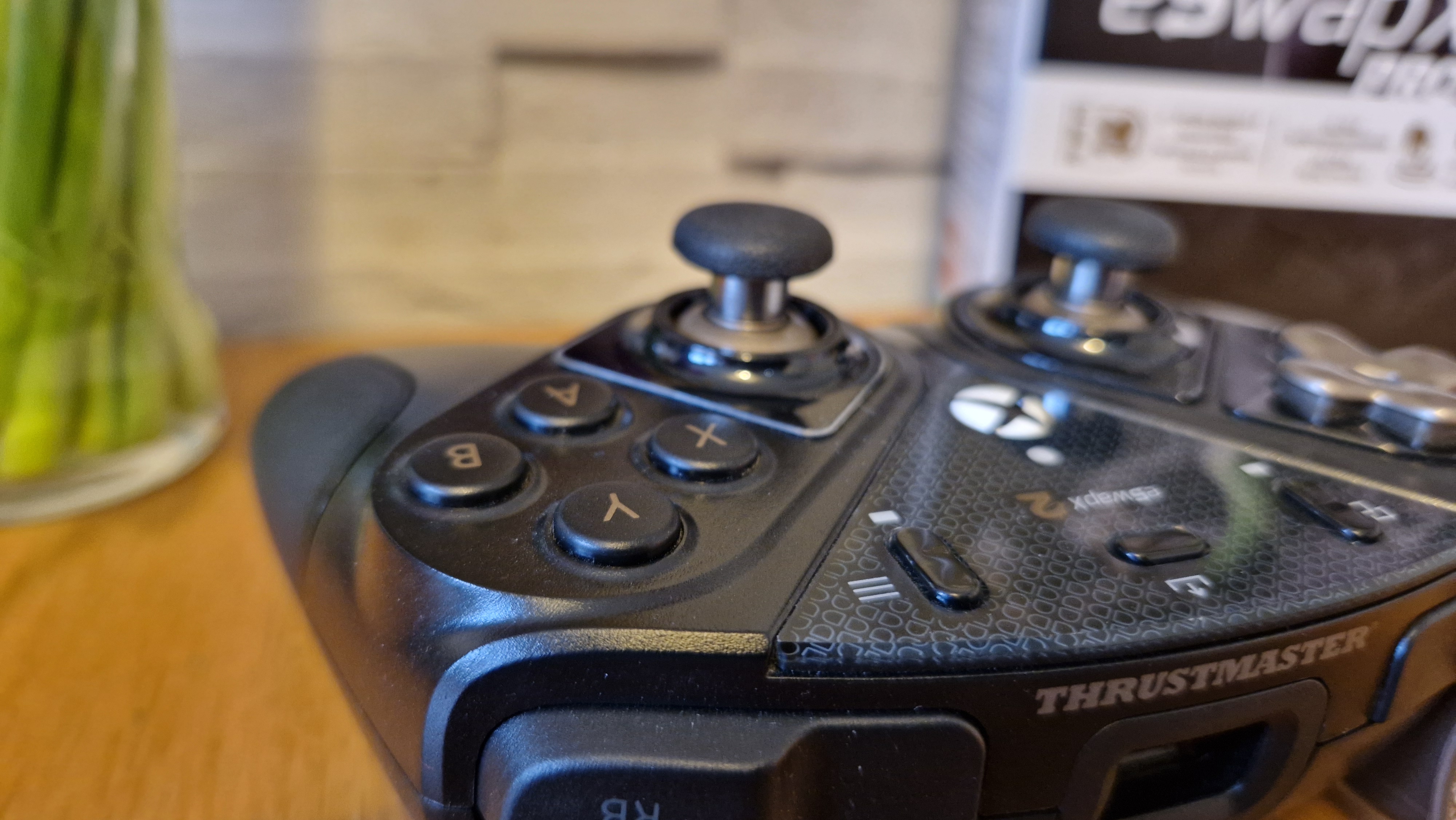 The Thrustmaster eSwap X2 controller on a wooden surface