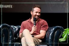 Ryan Reynolds sat on an arm chair speaking into a microphone