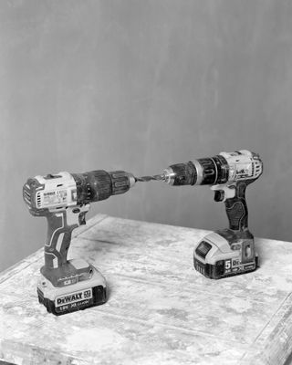A black and white photo of two drills facing each other