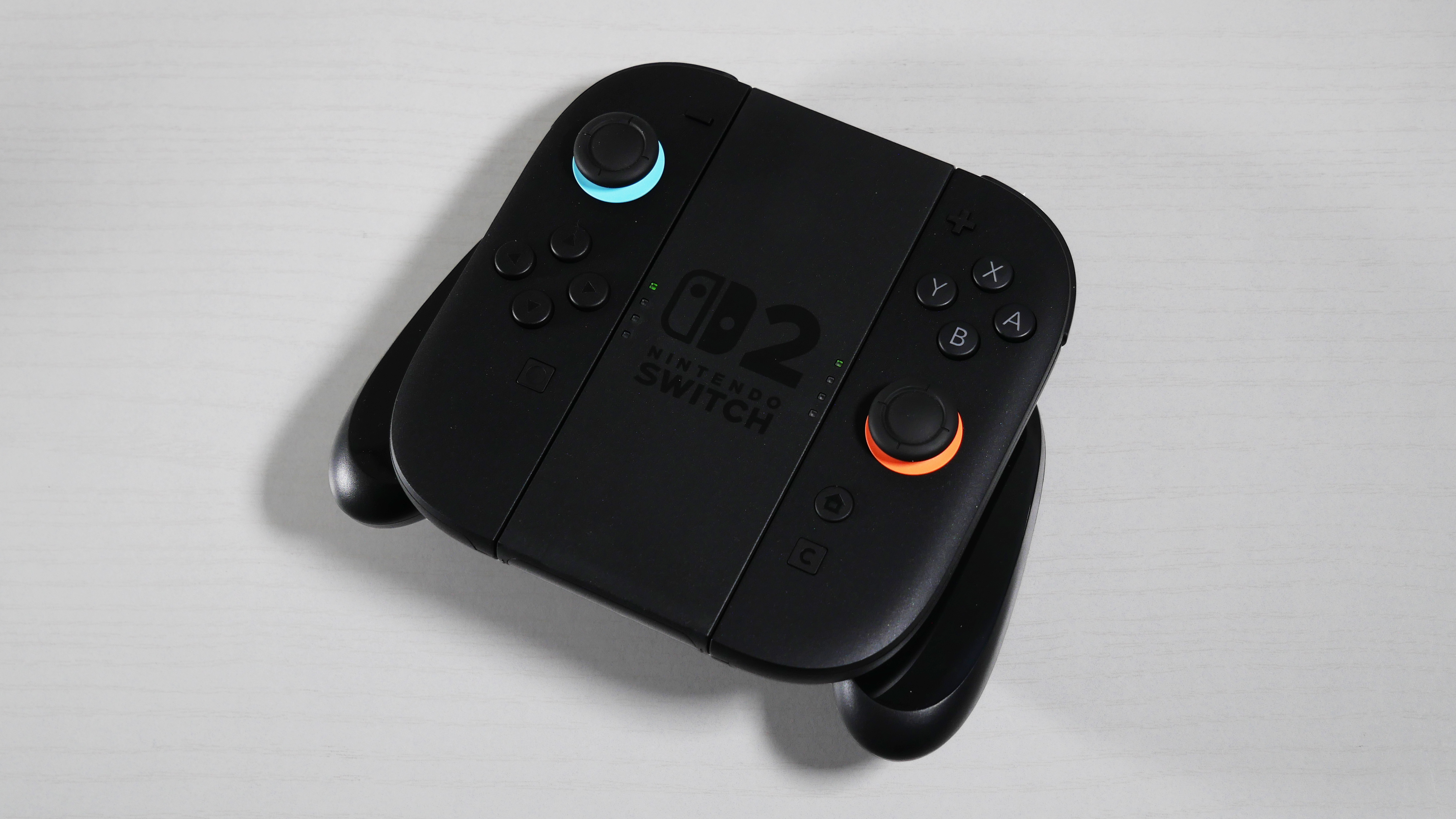 Nintendo Switch 2 Joy-Con 2 Grip lying on its back on a white desk.