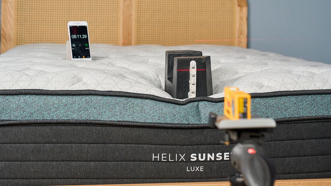 A 25kg weight is place on the foot of the Helix Sunset Luxe Mattress to measure its sturdiness and edge support.