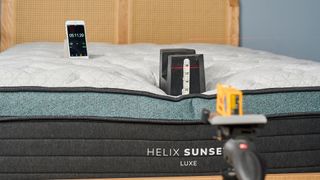 A 25kg weight is place on the foot of the Helix Sunset Luxe Mattress to measure its sturdiness and edge support.