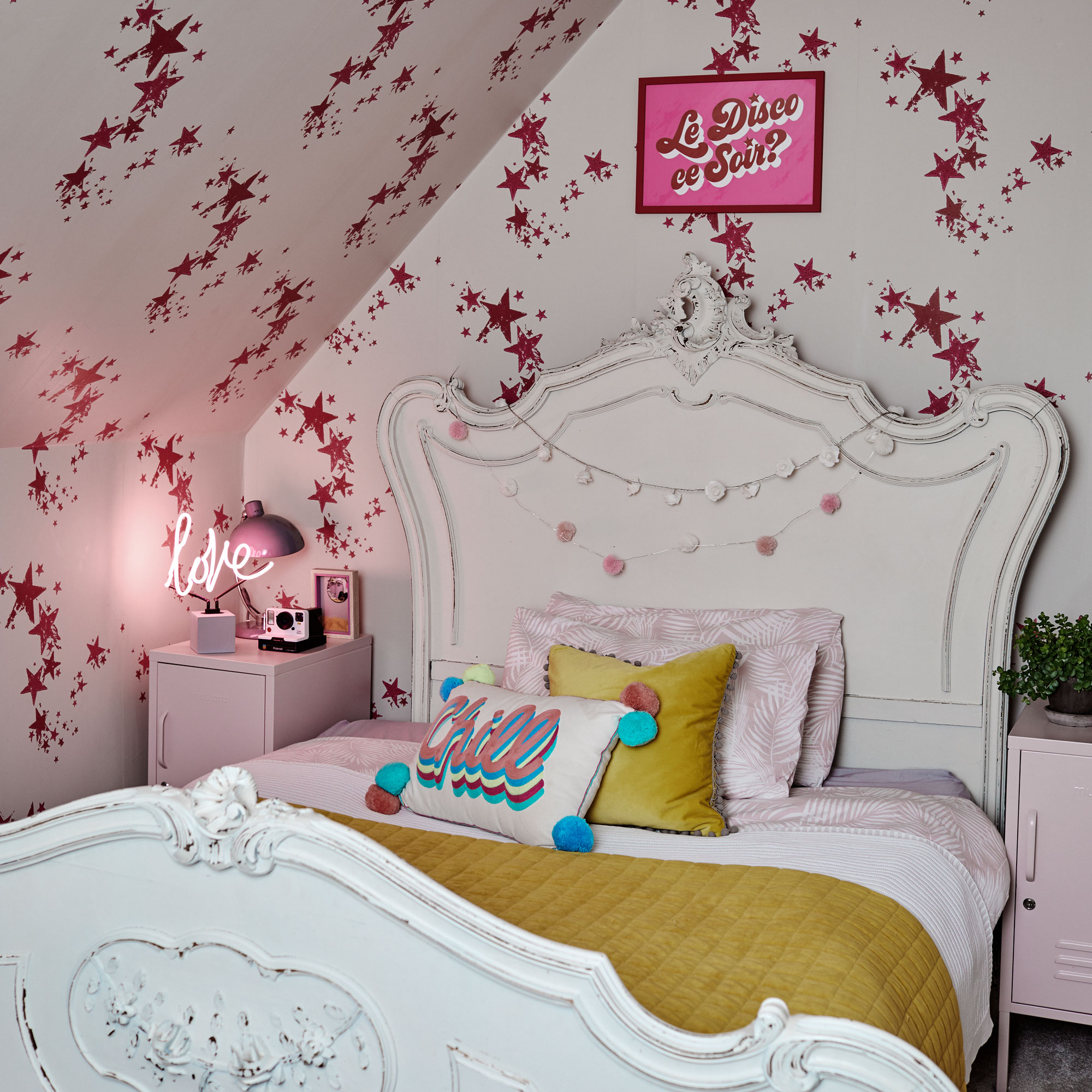 girl's bedroom with white vintage bed, star wallpaper and neon light